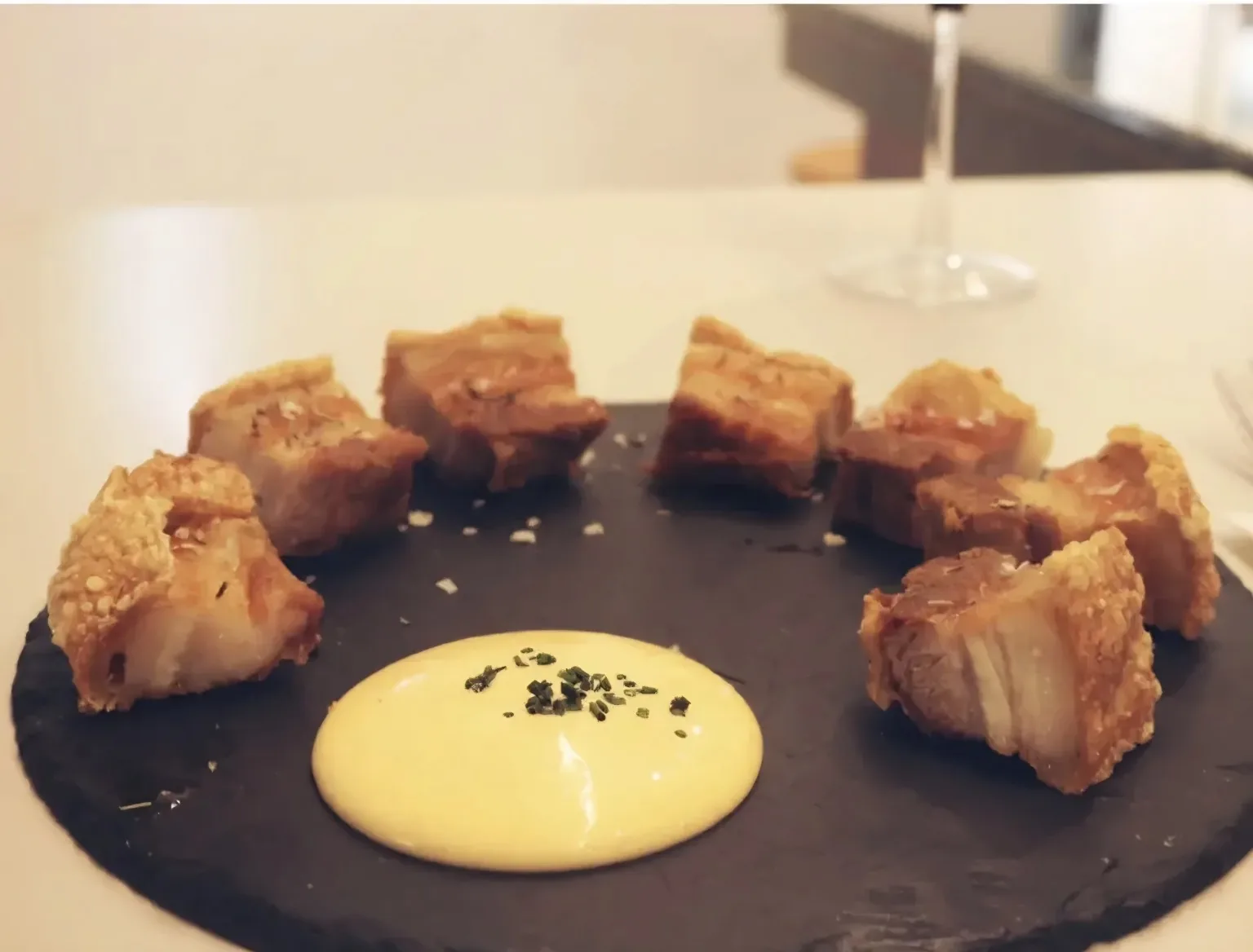 Torreznos servidos en pizarra con salsa